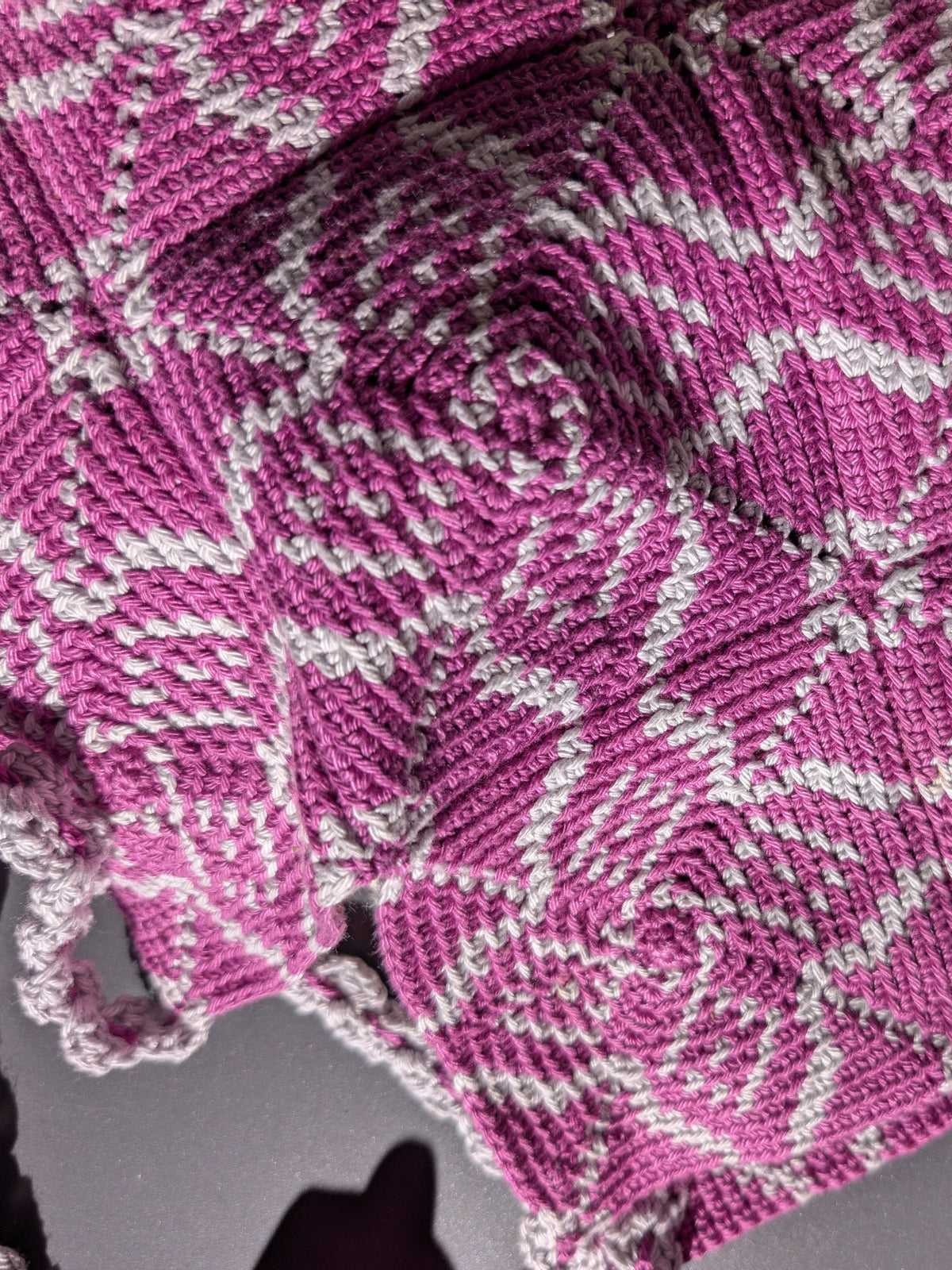 Close-up of the Pimlico tapestry crochet fabric, magenta and pale grey star tiles