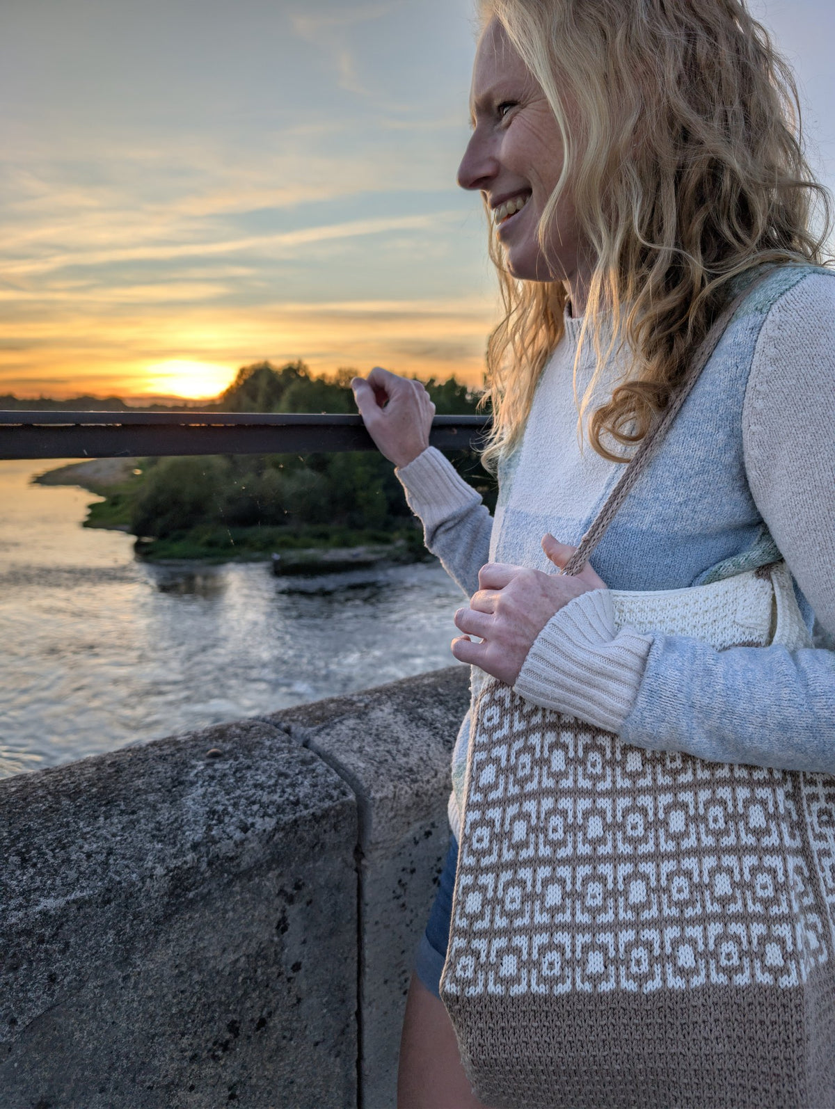 Cairo mosaic knitted tote bag worn on the shoulder at sunset by the river