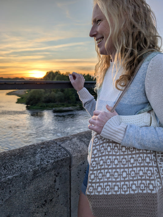 Cairo mosaic knitted tote bag worn on the shoulder at sunset by the river
