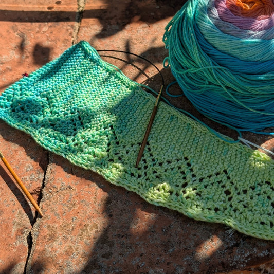 Sarlat lace shawl in progress with an Aura organic cotton cake on a sunlit terracotta terrace