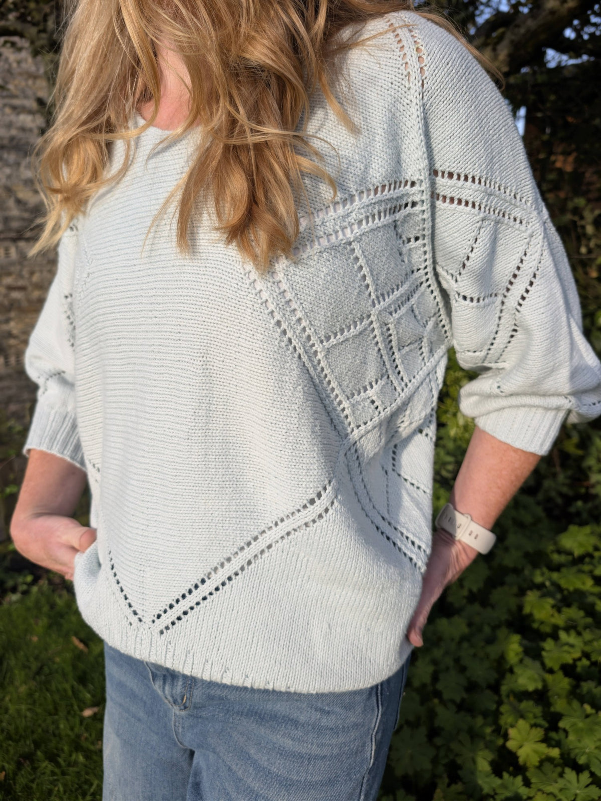 Close view of the Tessera lace on the sleeve and the eyelet V running to the hem